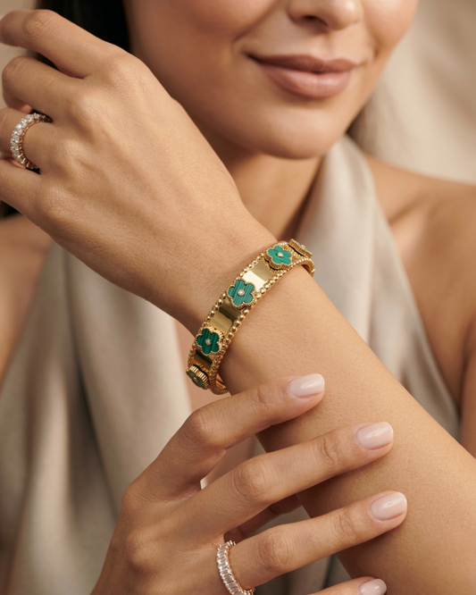 Maestra Emerald Bloom 18k gold-plated floral bangle with green accents, waterproof floral jewelry.