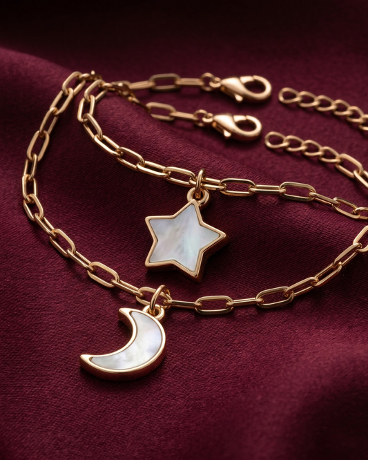 Gold plated star and moon charm bracelet stack for women. 2 piece layered celestial paperclip link bracelets India. Lightweight office wear jewelry for working women. Mother of pearl finish moon and star charm bracelet set alloy. Diwali and Rakhi jewelry gifts for wives. Gold tone festive wrist accessories for girls, women, and friends.