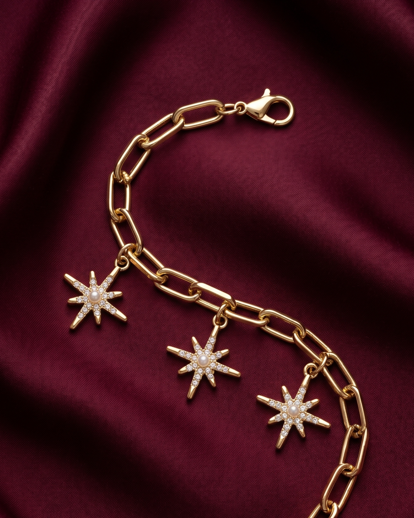 Gold plated star charm bracelet for women. Paperclip link celestial jewelry India. Lightweight office wear jewelry for working women. Crystal starburst charm bracelet alloy. Diwali and Rakhi jewelry gifts for wives. Gold tone festive wrist accessories for girls and friends.