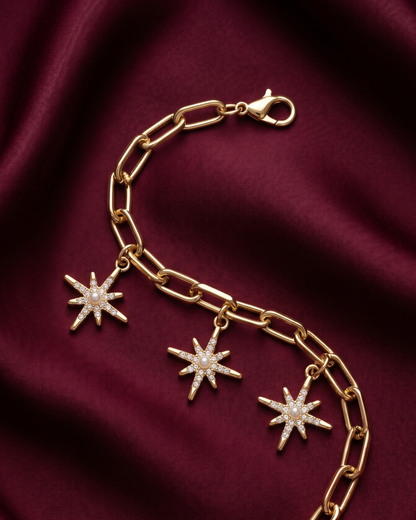 Gold plated star charm bracelet for women. Paperclip link celestial jewelry India. Lightweight office wear jewelry for working women. Crystal starburst charm bracelet alloy. Diwali and Rakhi jewelry gifts for wives. Gold tone festive wrist accessories for girls and friends.