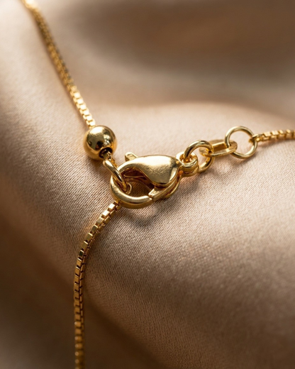 Gold bracelet on a beige fabric background