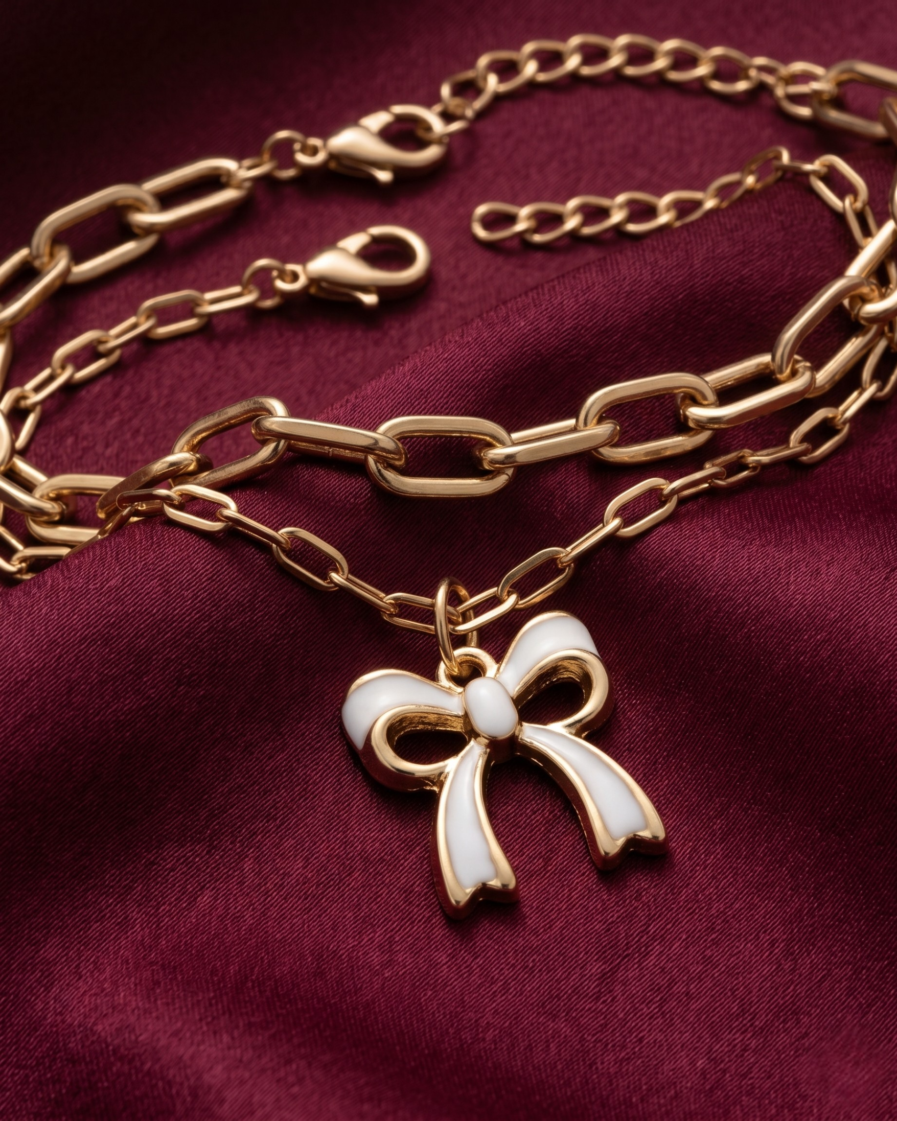 Gold plated white bow charm bracelet stack for women. 2 piece layered paperclip link bracelets India. Lightweight office wear jewelry for working women. White enamel ribbon charm bracelet set alloy. Diwali and Rakhi jewelry gifts for wives. Gold tone festive wrist accessories for girls, women, and friends.