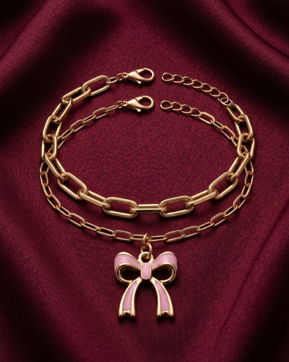 Gold plated white bow charm bracelet stack for women. 2 piece layered paperclip link bracelets India. Lightweight office wear jewelry for working women. White enamel ribbon charm bracelet set alloy. Diwali and Rakhi jewelry gifts for wives. Gold tone festive wrist accessories for girls, women, and friends.