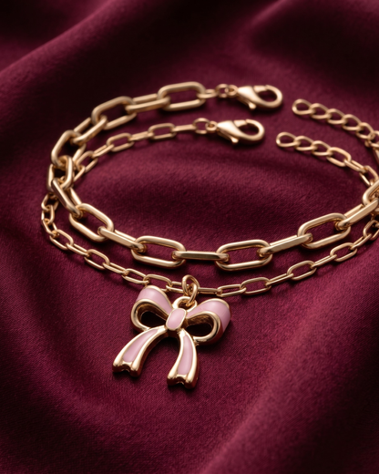 Gold plated white bow charm bracelet stack for women. 2 piece layered paperclip link bracelets India. Lightweight office wear jewelry for working women. White enamel ribbon charm bracelet set alloy. Diwali and Rakhi jewelry gifts for wives. Gold tone festive wrist accessories for girls, women, and friends.