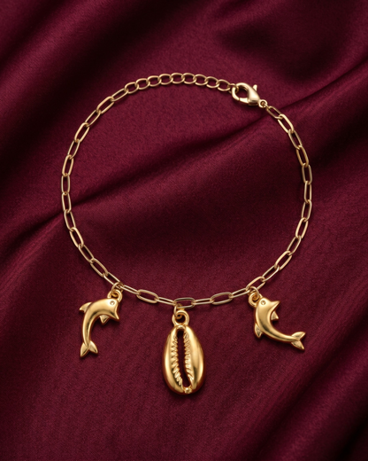 Gold plated cowrie shell and dolphin charm bracelet for women. Paperclip chain link marine charm bracelets India. Lightweight office wear jewelry for working women. Textured cowrie shell and dolphin charm bracelet set alloy. Holiday resort wear jewelry and gifts for wives. Gold tone beach theme wrist accessories for girls and friends