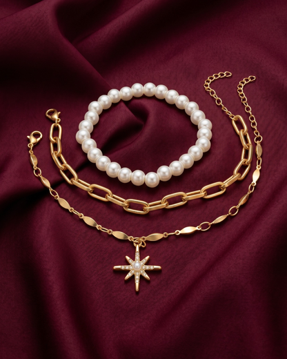Gold plated pearl and paperclip bracelet stack for women. 3 piece layered link bracelets India. Lightweight office wear jewelry for working women. White pearl and crystal starburst charm bracelet set alloy. Diwali and Rakhi jewelry gifts for wives. Gold tone festive wrist accessories for girls and friends.