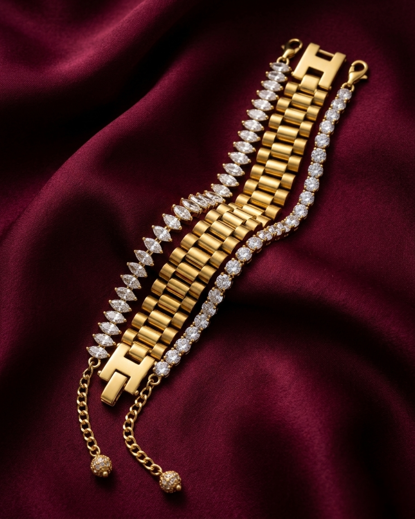 Premium anti-tarnish stainless steel watchlink, marquise, and American Diamond tennis bracelet stack on deep red fabric.