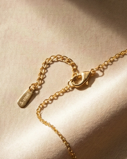 Gold bracelet with clasp on a beige fabric background