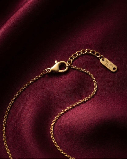Gold bracelet with clasp on a dark red fabric background