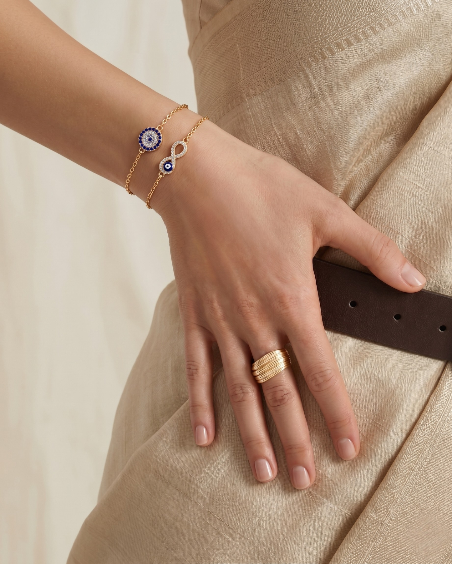 Gold plated evil eye bracelet stack for women. 2 piece layered infinity amulet jewelry India. Lightweight office wear jewelry for working women. Blue crystal studded charm bracelet set alloy. Diwali and Rakhi jewelry gifts for wives. Gold tone festive wrist accessories for girls and friends.