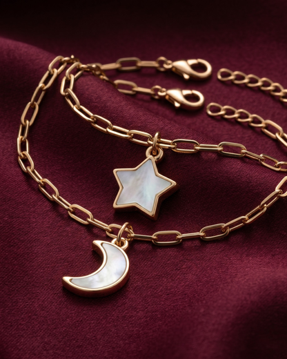 Gold plated star and moon charm bracelet stack for women. 2 piece layered celestial paperclip link bracelets India. Lightweight office wear jewelry for working women. Mother of pearl finish moon and star charm bracelet set alloy. Diwali and Rakhi jewelry gifts for wives. Gold tone festive wrist accessories for girls, women, and friends.