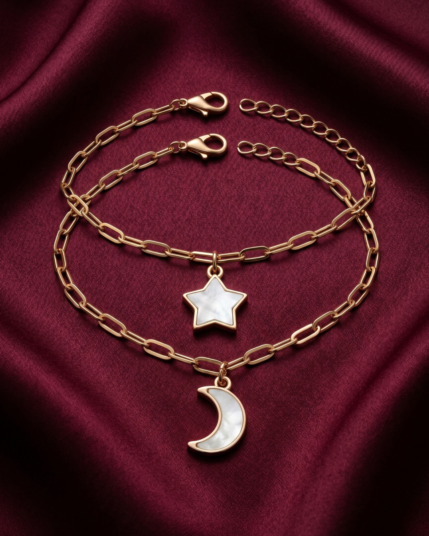 Gold plated star and moon charm bracelet stack for women. 2 piece layered celestial paperclip link bracelets India. Lightweight office wear jewelry for working women. Mother of pearl finish moon and star charm bracelet set alloy. Diwali and Rakhi jewelry gifts for wives. Gold tone festive wrist accessories for girls, women, and friends.