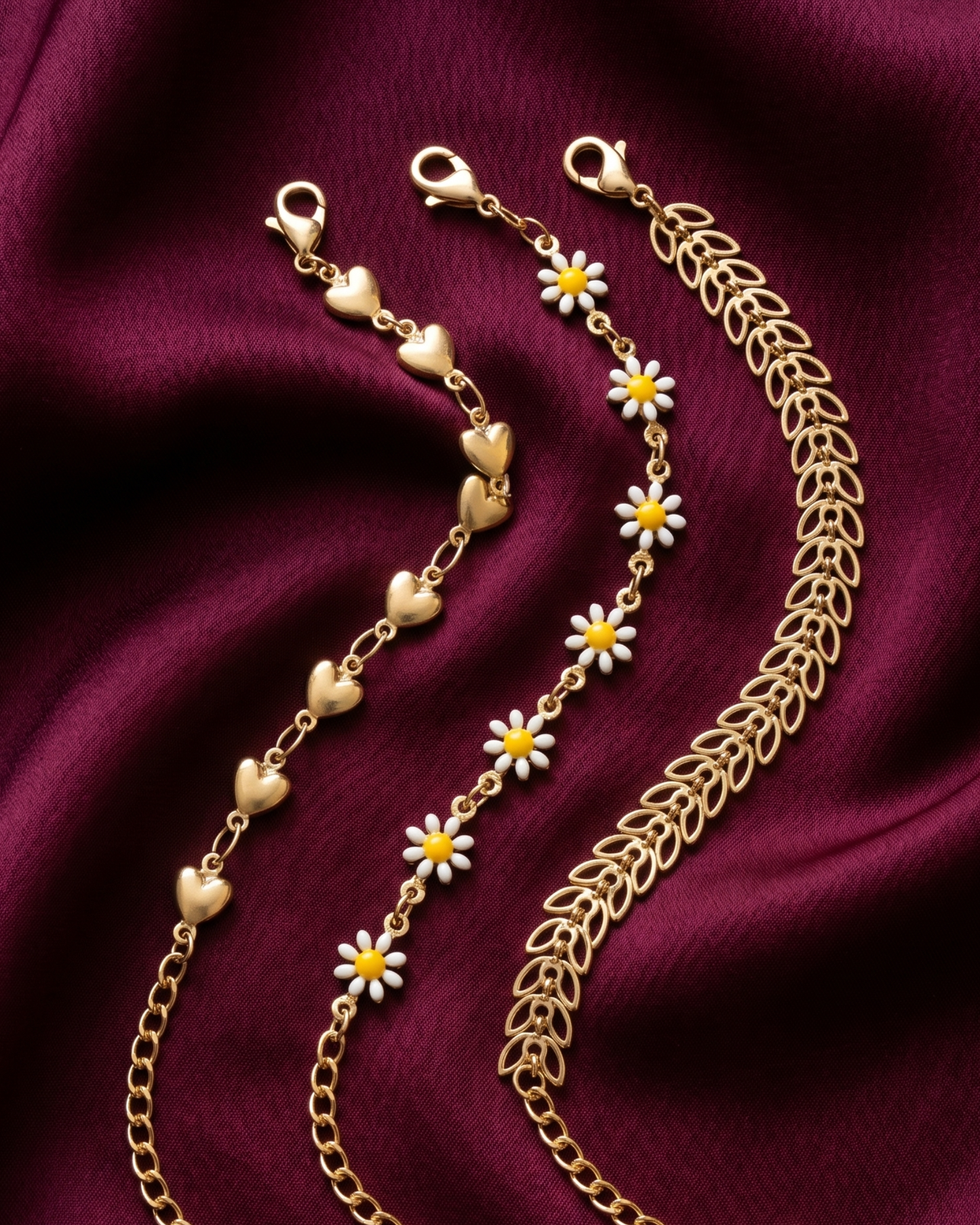 Gold plated heart and daisy bracelet stack for women. 3 piece layered link bracelets India. Lightweight office wear jewelry for working women. Enamel daisy and leaf charm bracelet set alloy. Diwali and Rakhi jewelry gifts for wives. Gold tone festive wrist accessories for girls and friends.