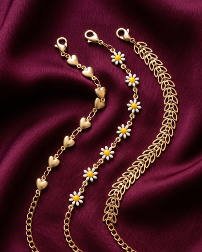 Gold plated heart and daisy bracelet stack for women. 3 piece layered link bracelets India. Lightweight office wear jewelry for working women. Enamel daisy and leaf charm bracelet set alloy. Diwali and Rakhi jewelry gifts for wives. Gold tone festive wrist accessories for girls and friends.