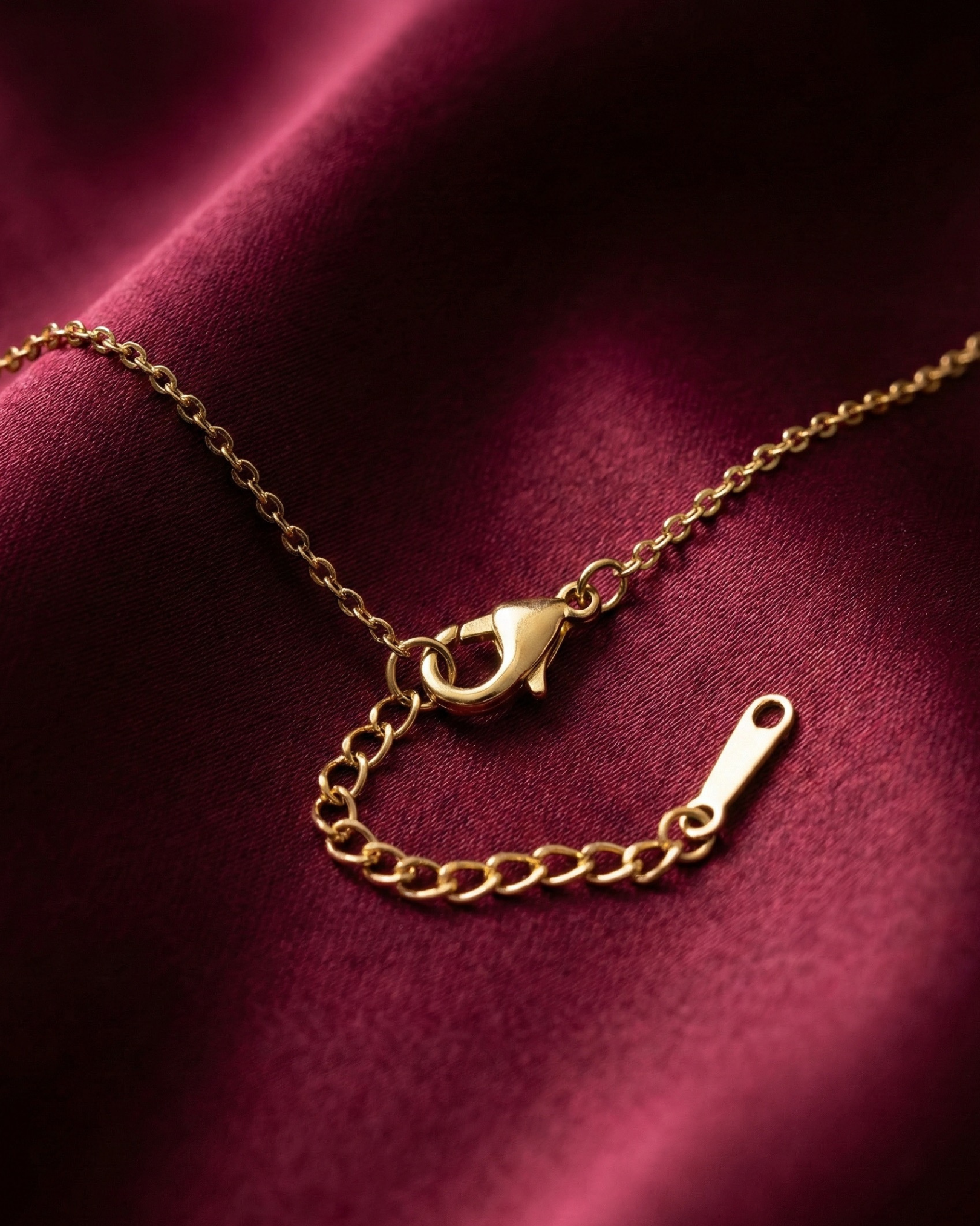 Gold chain necklace on a red fabric background