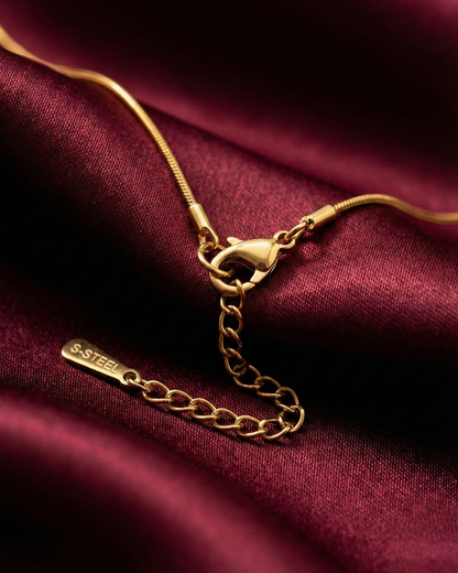 Gold necklace on a burgundy fabric background