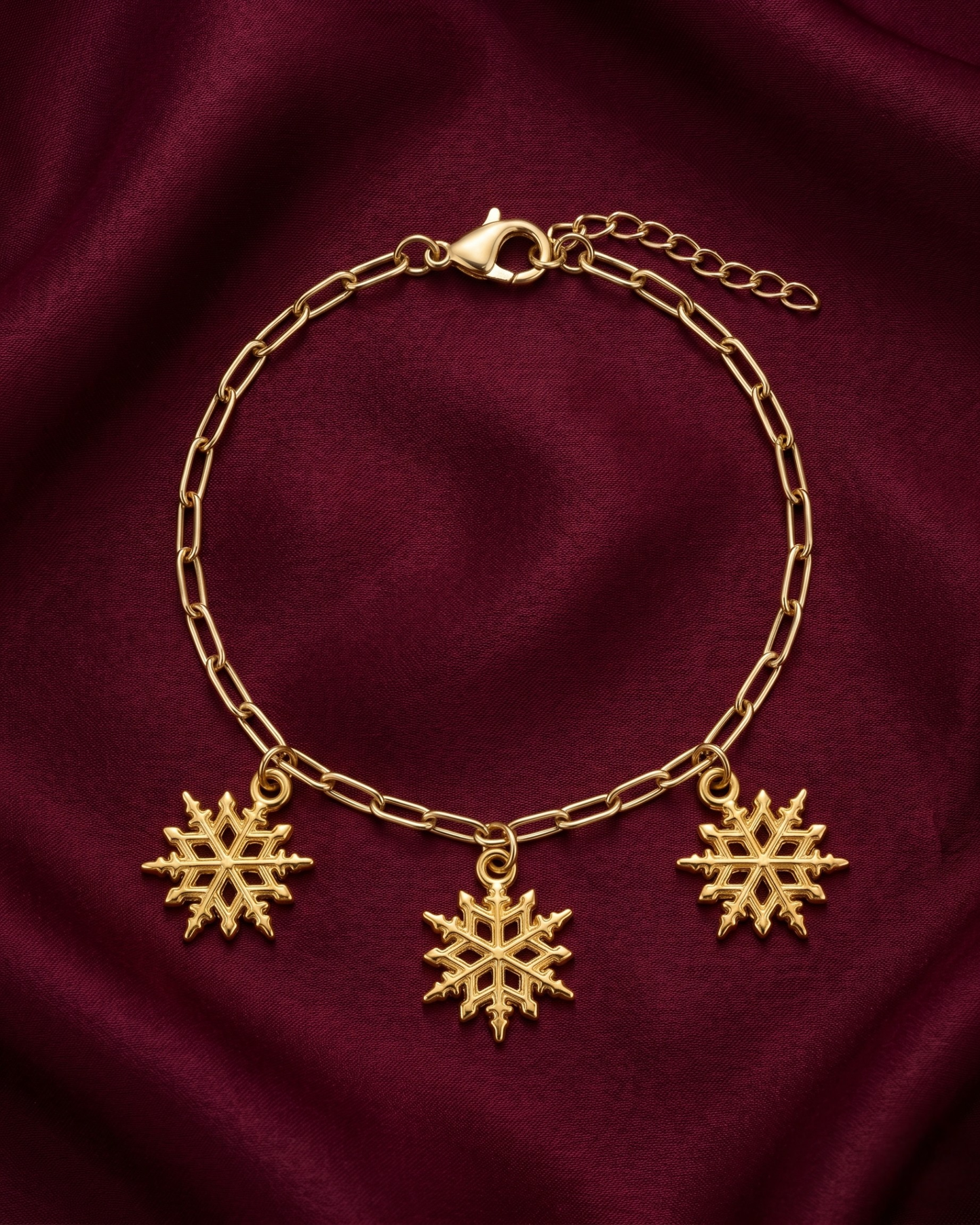 Gold plated snowflake charm bracelet for women. Paperclip chain link winter jewelry India. Lightweight office wear jewelry for working women. 3 snowflake charm hanging bracelet alloy. Diwali, Navratri, and Rakhi jewelry gifts for wives. Gold tone festive wrist accessories for girls, women, and friends.