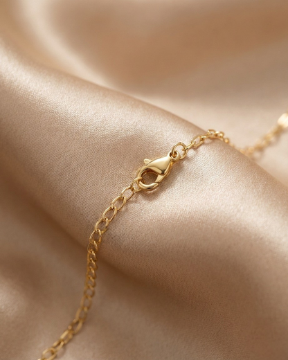 Gold bracelet on a soft beige fabric background