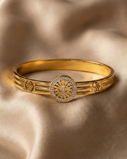Maestra Sentinel 18k gold-plated evil eye and hamsa bangle, protective waterproof jewelry with symbolic charms.