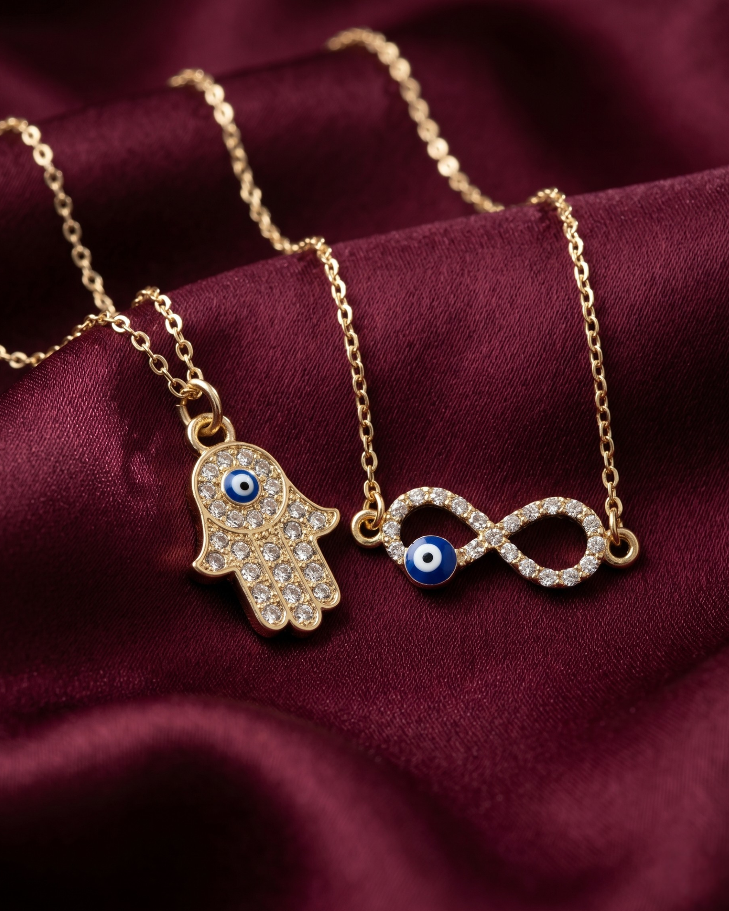 Gold plated evil eye and hamsa necklace set for women. 2 piece layered protective pendant jewelry India. Lightweight office wear necklaces for working women. Crystal studded hamsa hand and infinity charm necklace alloy. Diwali, Navratri, and Rakhi jewelry gifts for wives. Gold tone festive neck accessories for girls, women, and friends.