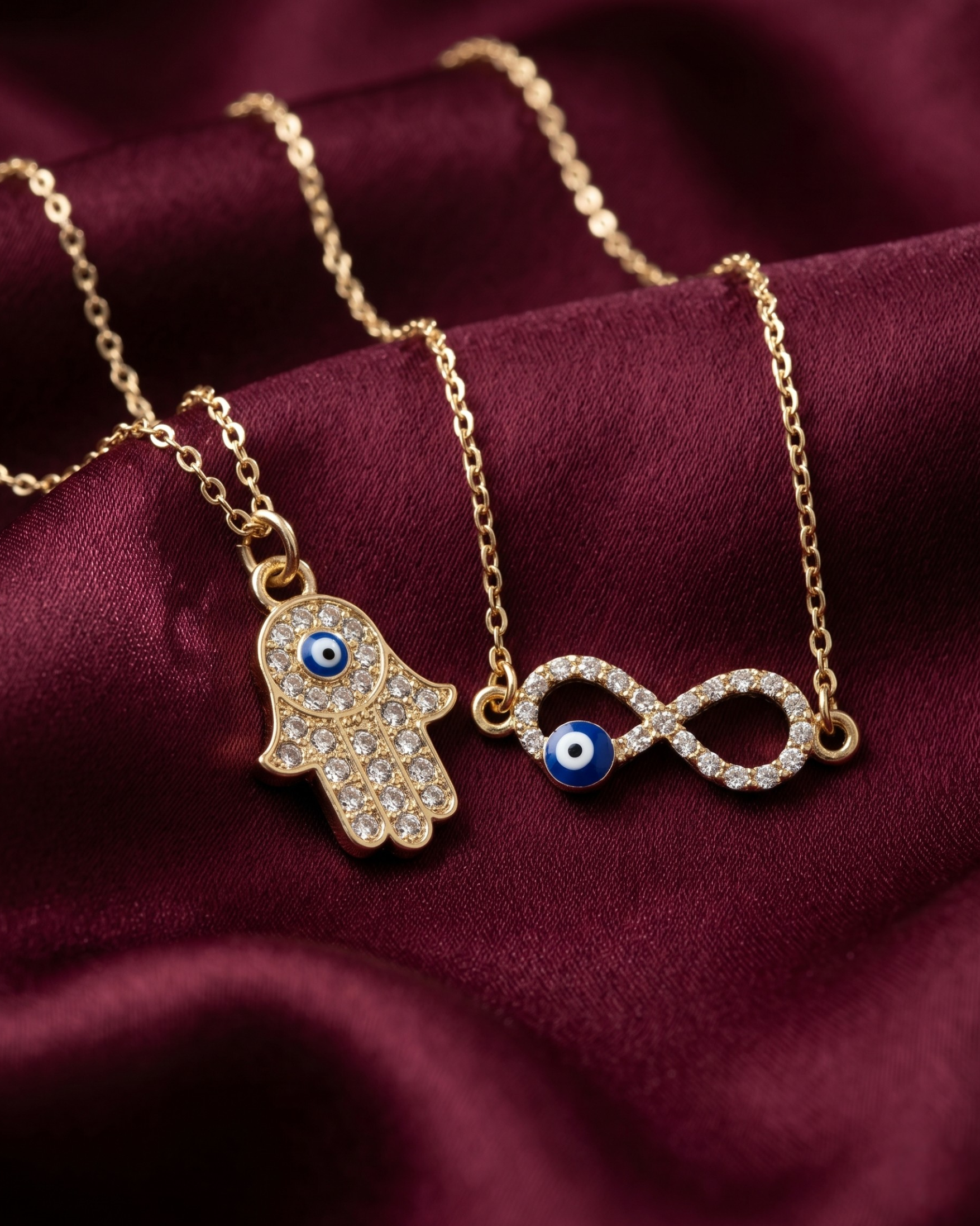 Gold plated evil eye and hamsa necklace set for women. 2 piece layered protective pendant jewelry India. Lightweight office wear necklaces for working women. Crystal studded hamsa hand and infinity charm necklace alloy. Diwali, Navratri, and Rakhi jewelry gifts for wives. Gold tone festive neck accessories for girls, women, and friends.