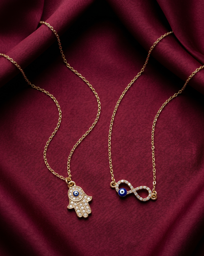 Gold plated evil eye and hamsa necklace set for women. 2 piece layered protective pendant jewelry India. Lightweight office wear necklaces for working women. Crystal studded hamsa hand and infinity charm necklace alloy. Diwali, Navratri, and Rakhi jewelry gifts for wives. Gold tone festive neck accessories for girls, women, and friends.